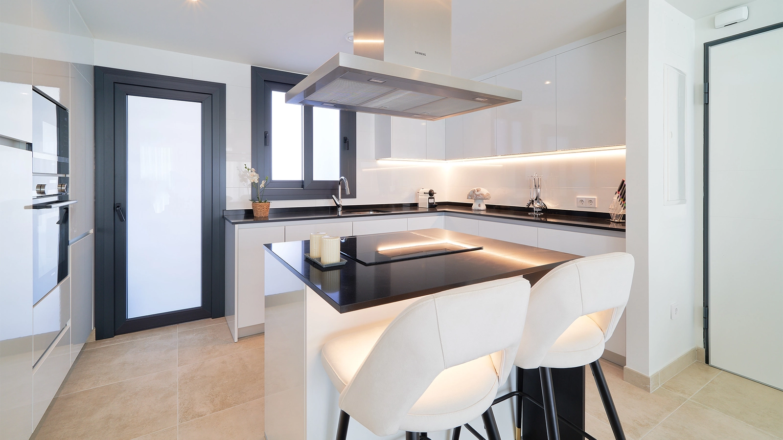 Et moderne, fullt utstyrt kjøkken med hvitevarer av høy kvalitet og en stilig kjøkkenøy.