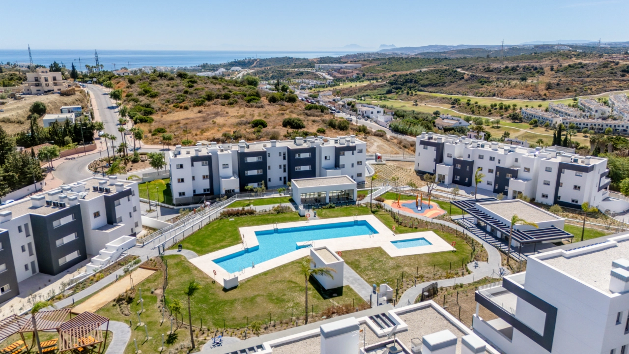 Et fantastisk perspektiv av det ferdige prosjektet, som viser svømmebassengene og grøntområdene med havet i horisonten.