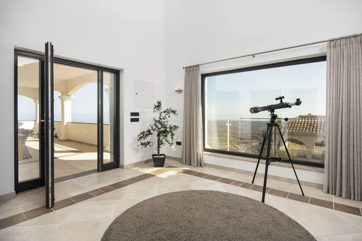 Et fredelig hjørne av hjemmet hvor store vinduer rammer inn det spektakulære landskapet og dører åpner ut mot terrassen.