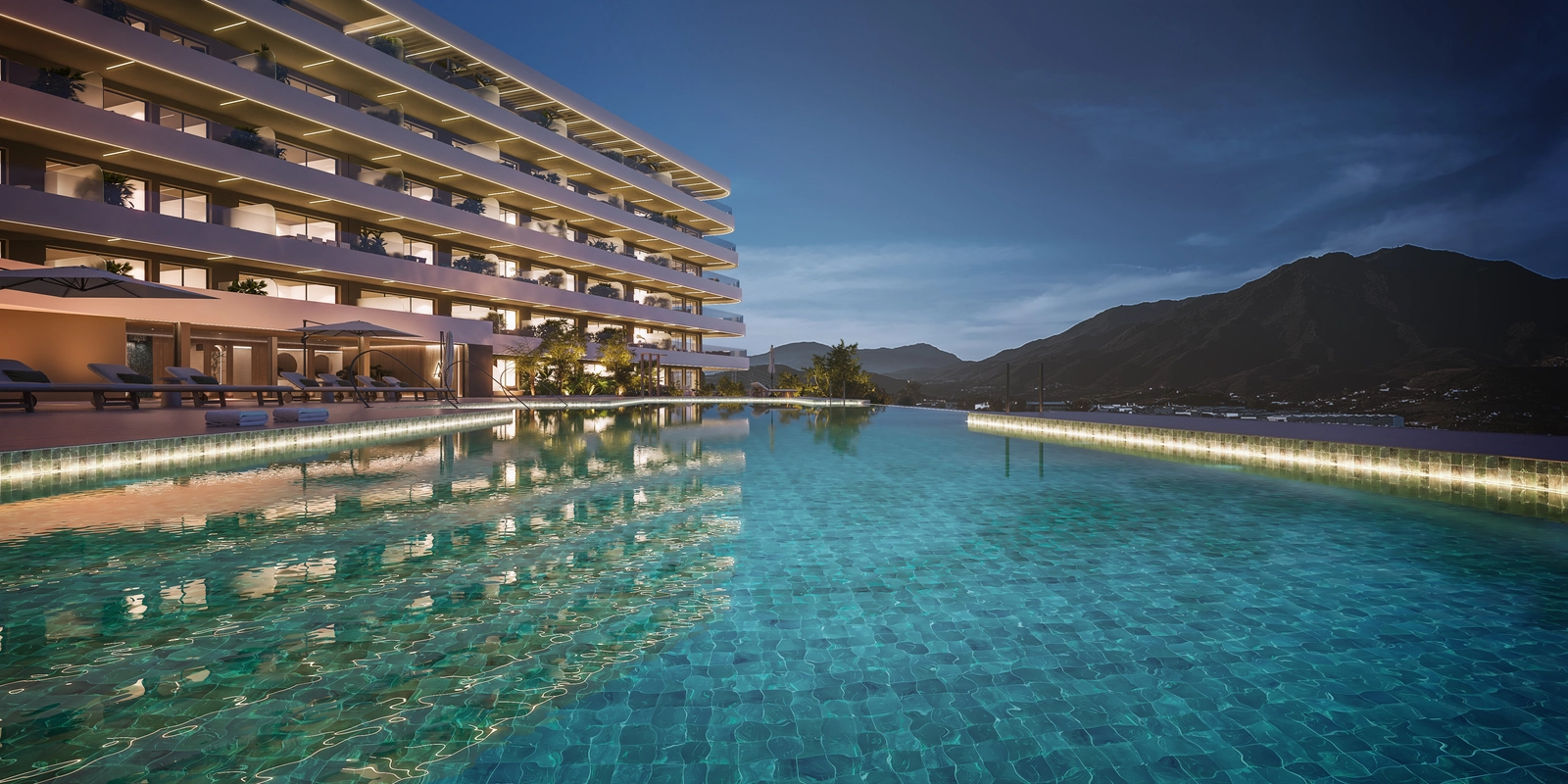 Felles infinity-bassengområde i skumringen, som tilbyr et rolig sted å svømme og slappe av mens du nyter fjellutsikten.