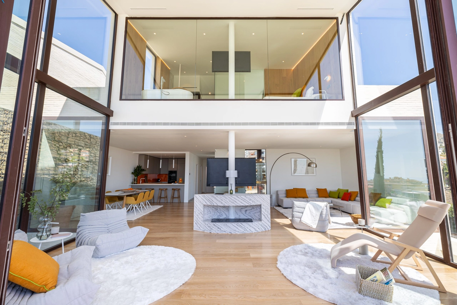 En utsikt inn i den doble takhøyde-stuen, hvor arkitektur og natur føles forbundet.