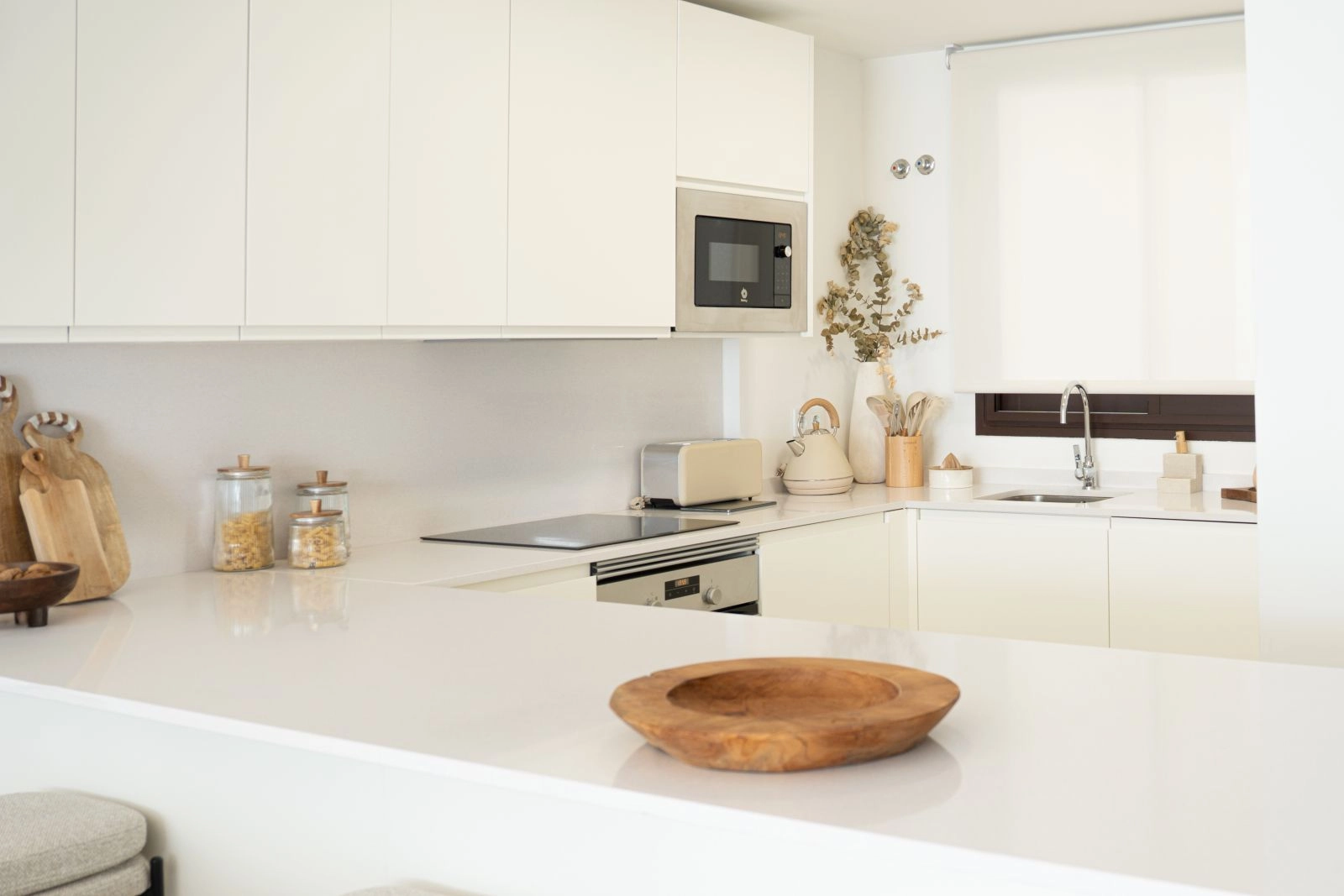 Et elegant, moderne kjøkken fullt utstyrt med hvitevarer av høy kvalitet, perfekt for hverdagsbruk og underholdning.