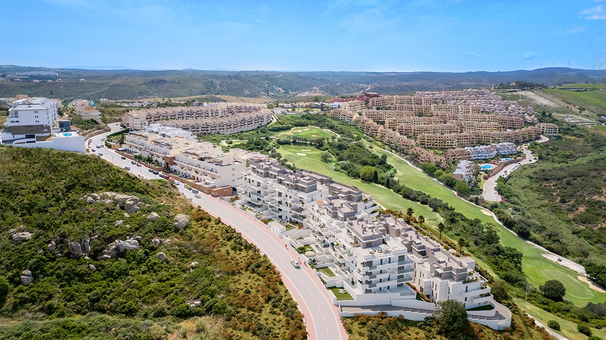 Et flyfoto av anlegget, perfekt integrert i det frodige grønne landskapet på Costa del Sol med nærliggende golfbaner.