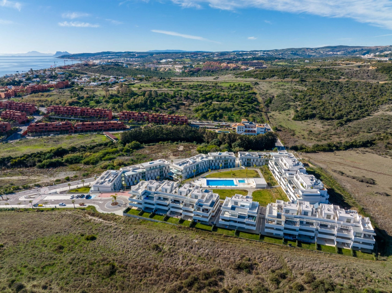 Det sentrale svømmebassenget og solområdet, omgitt av anlagte hager, skaper en privat oase for beboerne.