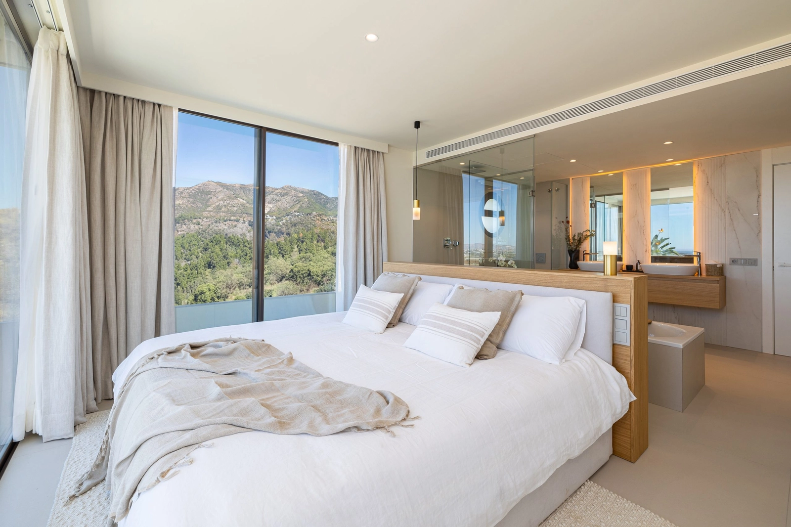 Hovedsoverommet er et fredelig tilfluktssted, med et åpent eget bad og store vinduer med rolig utsikt.